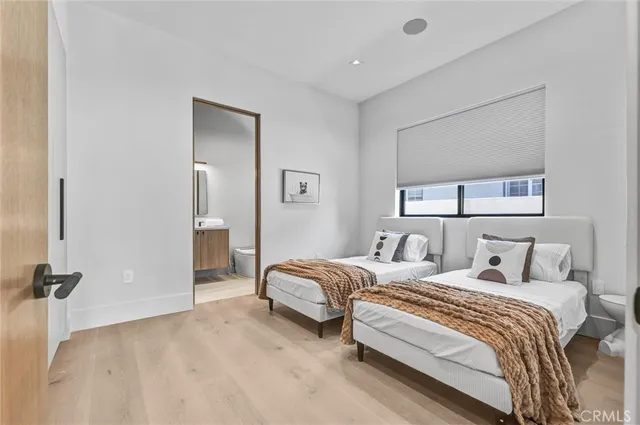 a bedroom with two beds and painting on the wall