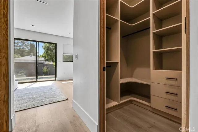 a view of walk in closet with empty racks