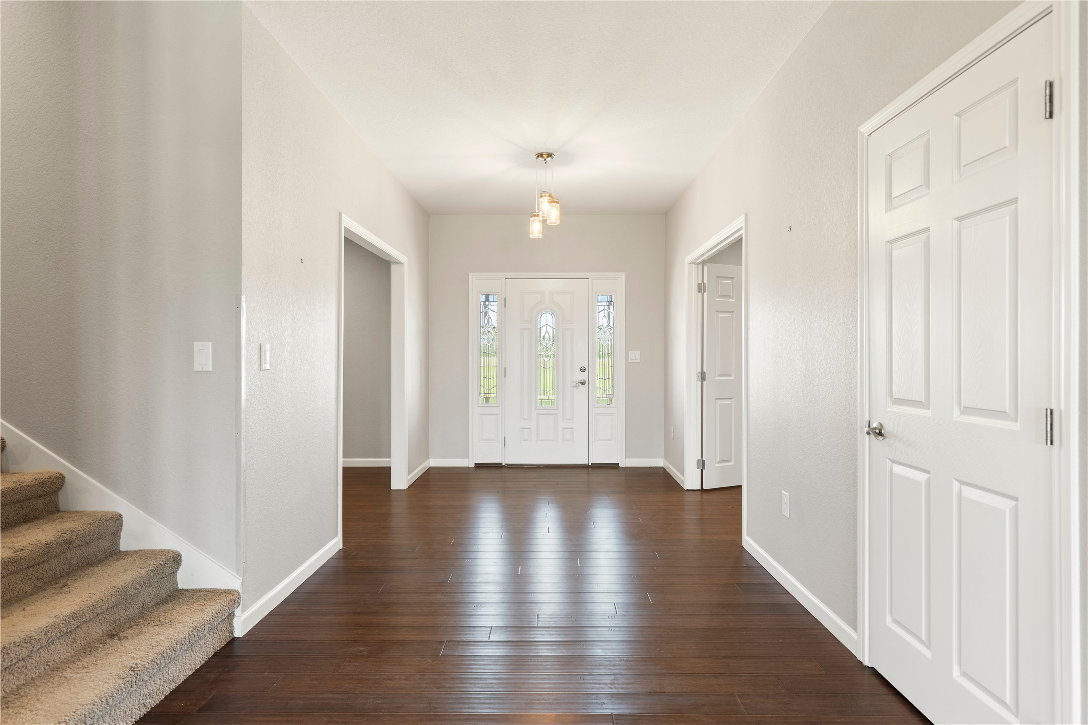 1293 Pioneer Road Seguin, TX 78155 - Photo 21 of 40 A spacious entry hallway features lustrous hardwood flooring and an inviting front door with decorative glass panels.