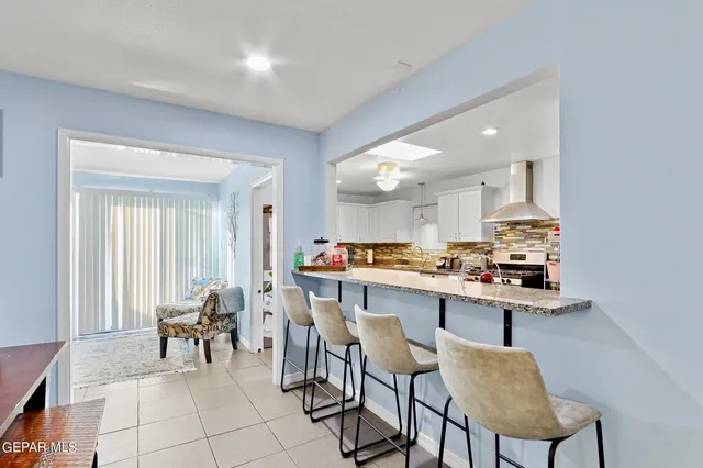 a room with stainless steel appliances a dining table and chairs