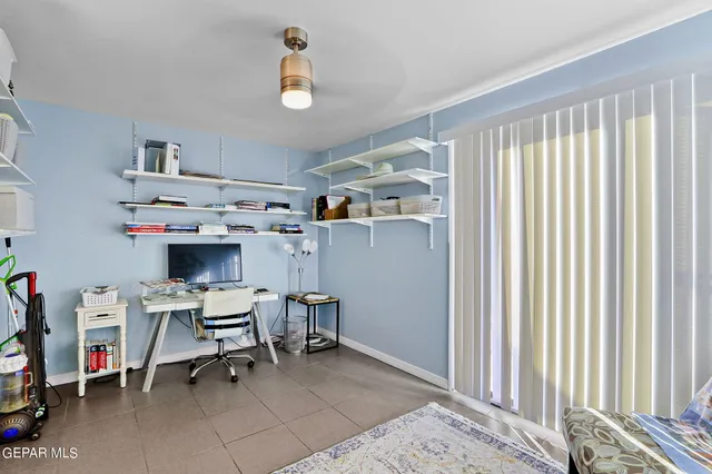 a view of a workspace with furniture and a window