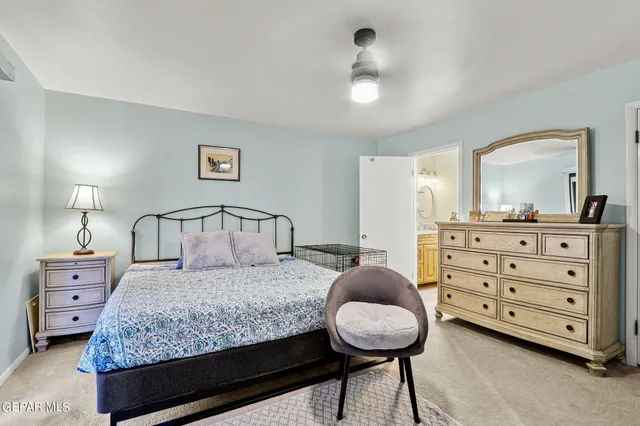 a bedroom with a large bed and a chandelier