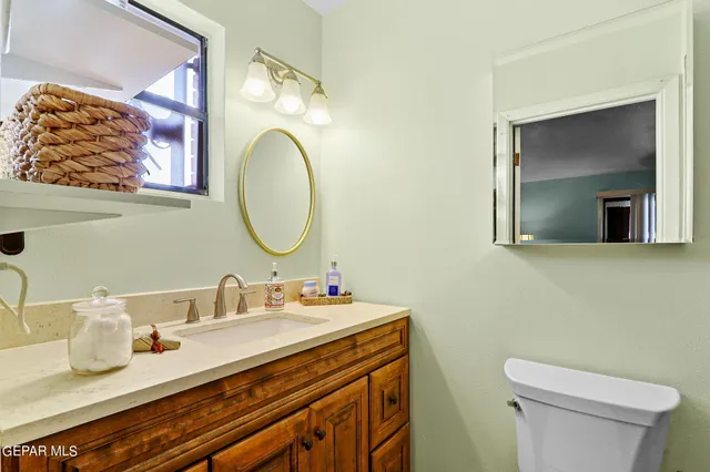 a bathroom with a granite countertop double vanity sink and a mirror