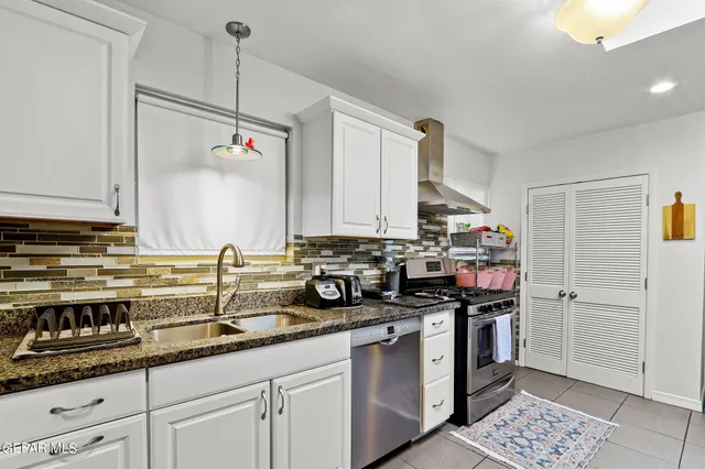 a kitchen with stainless steel appliances granite countertop a sink stove and cabinets