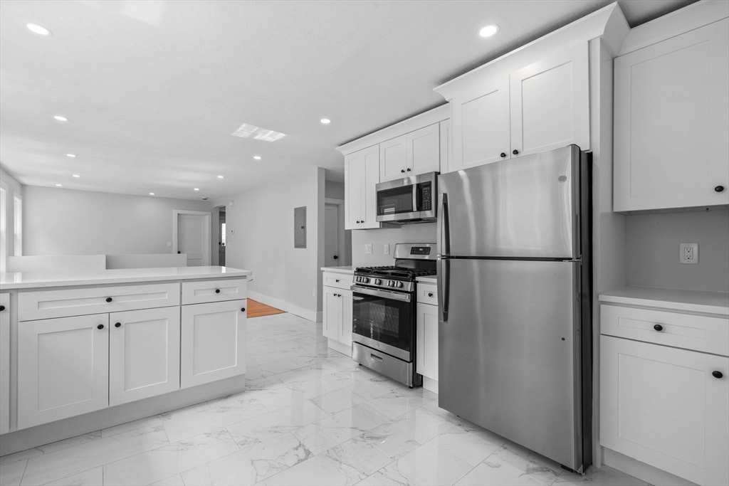 a kitchen with white cabinets and stainless steel appliances