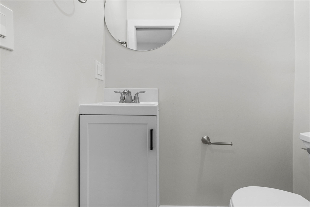 170 Calumet Street, Unit 1 Boston, MA 02120 - Photo 18 of 21 a bathroom with a toilet sink and mirror