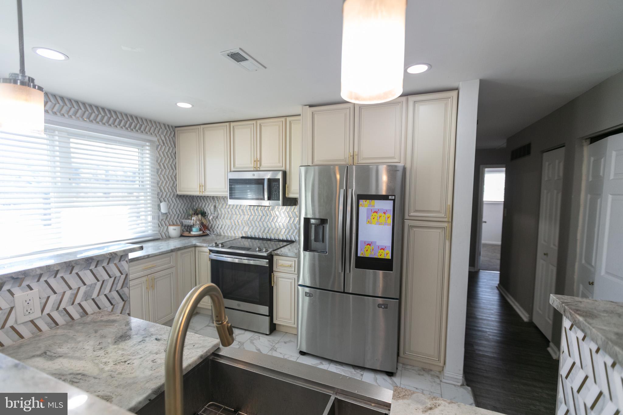 750 Miller Drive Dover, DE 19901 - Photo 5 of 49 a kitchen with stainless steel appliances granite countertop a refrigerator a sink a stove and white cabinets