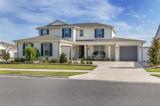 a front view of a house with a yard and palm trees
