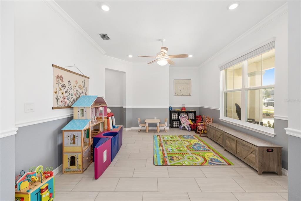 7208 Southwest 65th Place Road Ocala, FL 34474 - Photo 28 of 76 a living room with furniture gym equipment and a chandelier