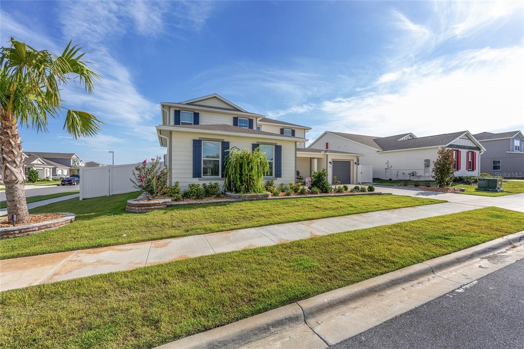 7208 Southwest 65th Place Road Ocala, FL 34474 - Photo 3 of 76 a front view of a house with a garden and yard