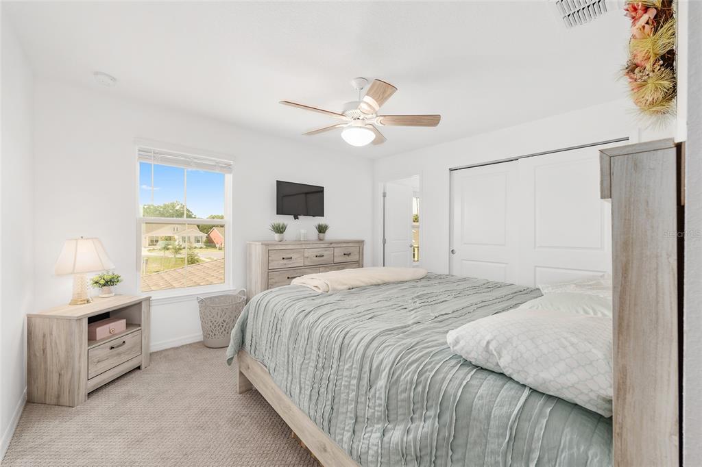 7208 Southwest 65th Place Road Ocala, FL 34474 - Photo 41 of 76 a spacious bedroom with a bed and a ceiling fan