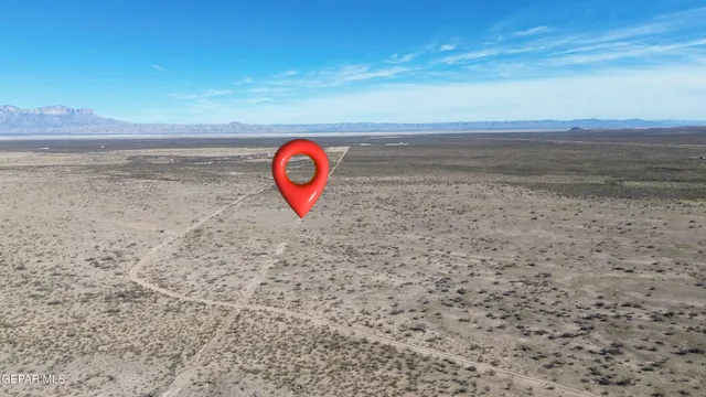 a view of a dry yard with wooden fence