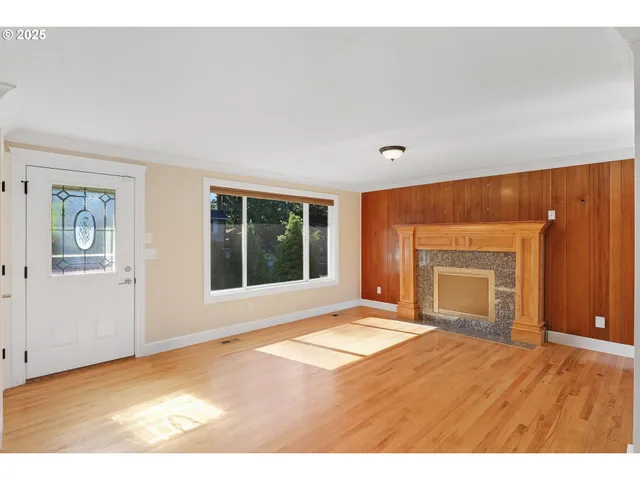 a view of an empty room with a window and a fireplace