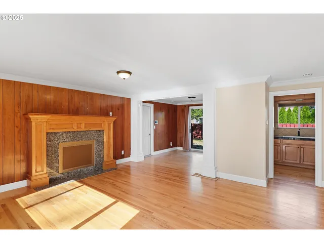 a view of an empty room with window and fire place