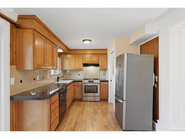a kitchen with granite countertop a refrigerator and a sink