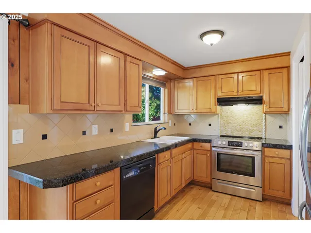 a kitchen with stainless steel appliances granite countertop a sink stove and cabinets