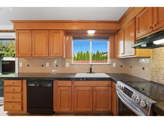 a kitchen with granite countertop a sink stainless steel appliances and cabinets