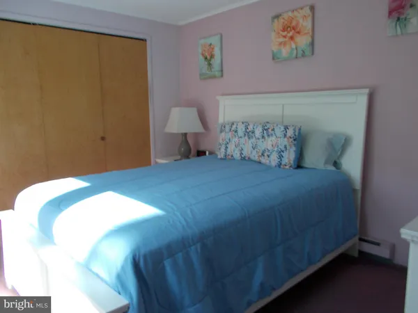 a bedroom with a bed and painting on the wall