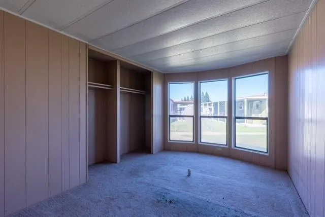 an empty room with windows and closet