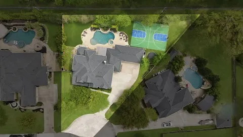 an aerial view of a house with a garden and trees