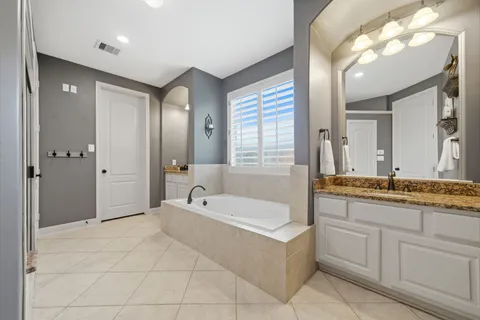a bathroom with a granite countertop sink a mirror and a shower