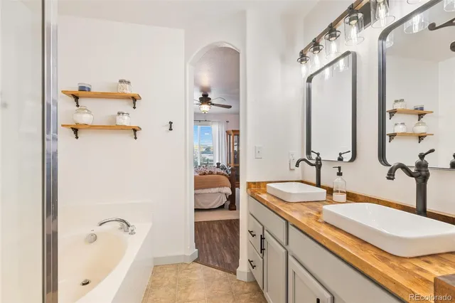 a bathroom with a sink and mirror with bathtub