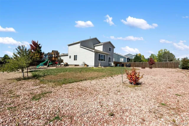 a view of an house with backyard space and balcony