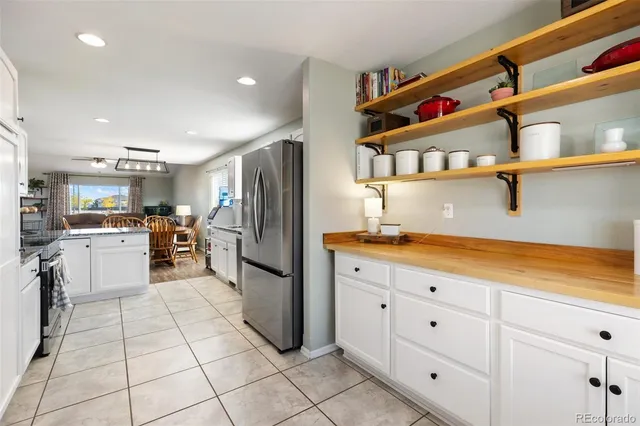 a kitchen with white cabinets and refrigerator
