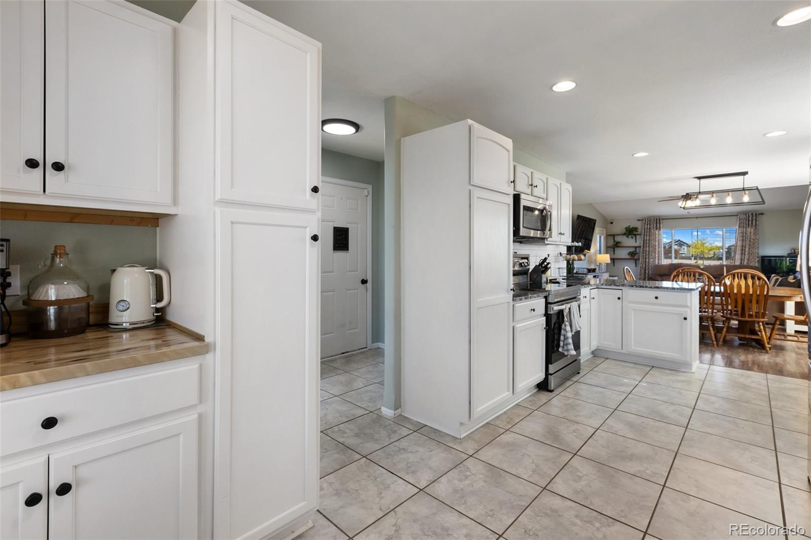 9201 Ballybunion Road Peyton, CO 80831 - Photo 9 of 32 a kitchen with white cabinets and white appliances