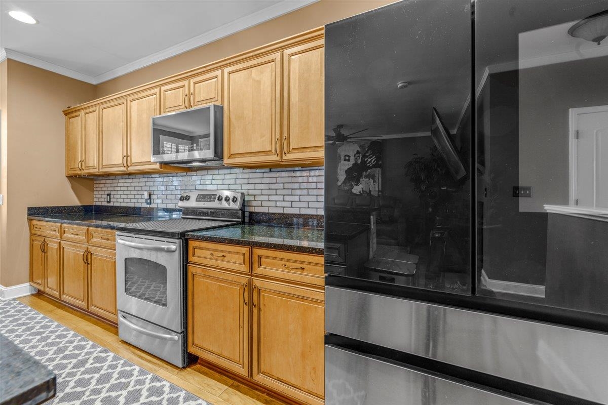 79 Shoemaker Court, Unit 104 Memphis, TN 38103 - Photo 9 of 22 a kitchen with stainless steel appliances granite countertop a stove a sink and a microwave