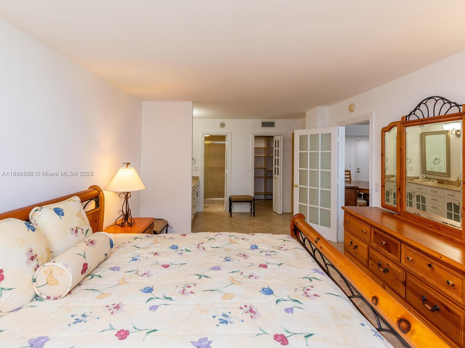 9273 Collins Avenue, Unit 703 Surfside, FL 33154 - Photo 13 of 49 a bed room with a bed and a large mirror