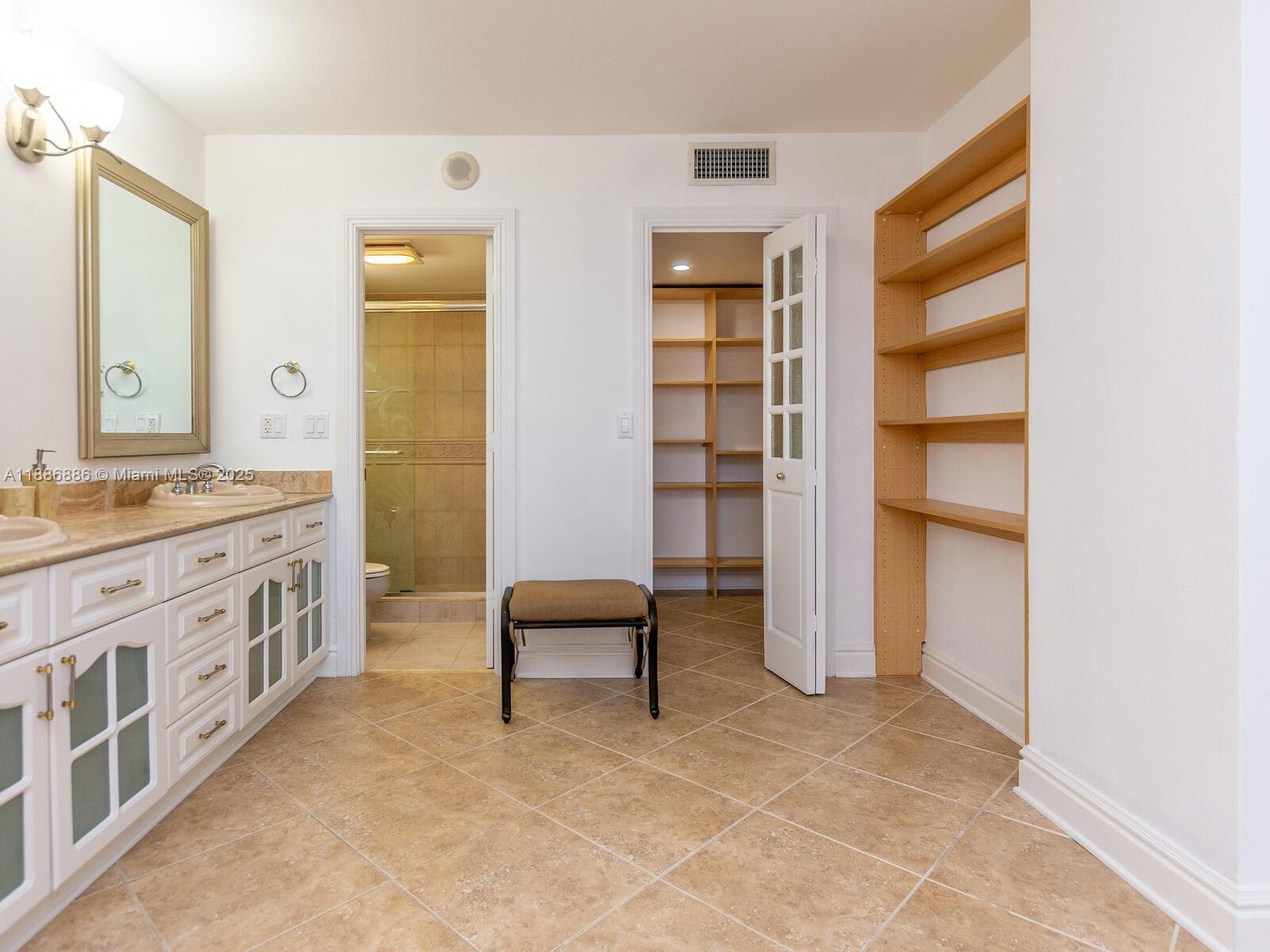 9273 Collins Avenue, Unit 703 Surfside, FL 33154 - Photo 14 of 49 a spacious bathroom with a double vanity sink and a mirror