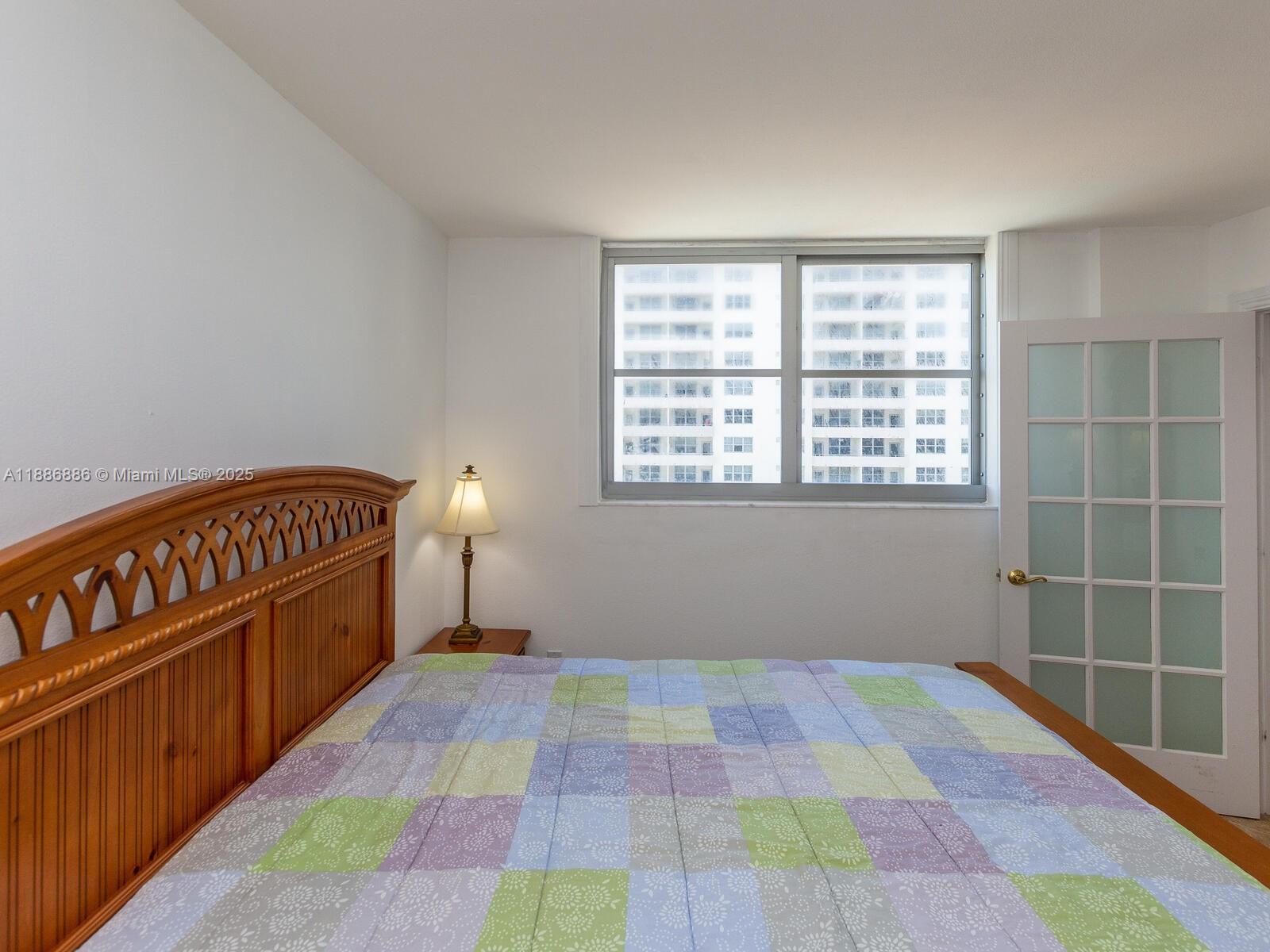 9273 Collins Avenue, Unit 703 Surfside, FL 33154 - Photo 22 of 49 a bedroom with a bed and a window