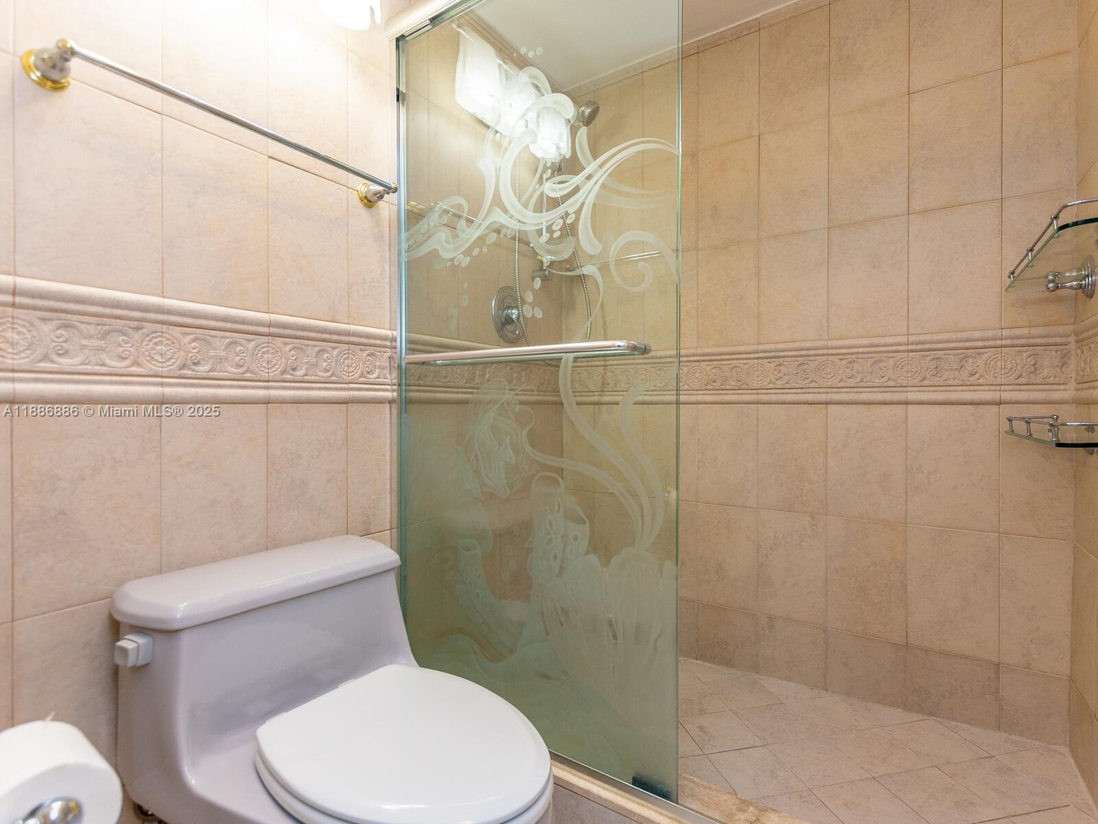 9273 Collins Avenue, Unit 703 Surfside, FL 33154 - Photo 24 of 49 a white toilet sitting next to a bathroom shower