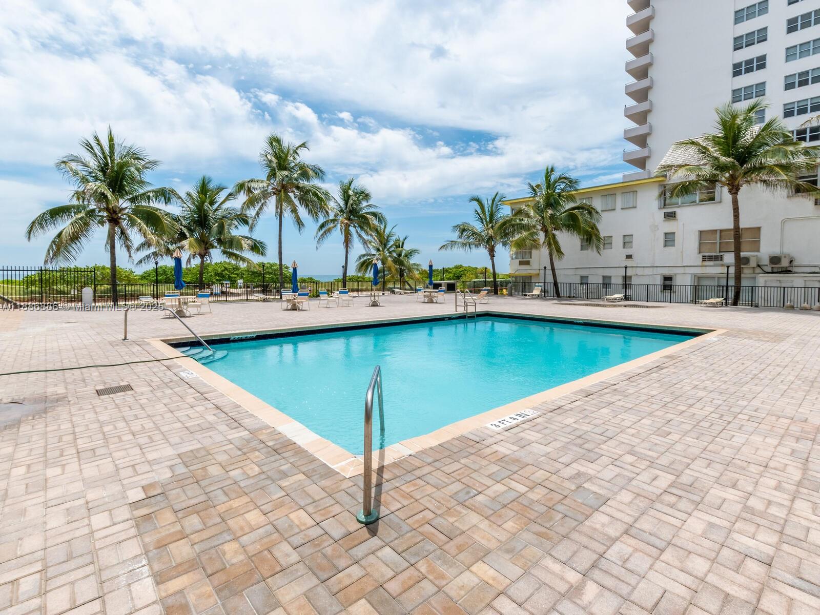 9273 Collins Avenue, Unit 703 Surfside, FL 33154 - Photo 30 of 49 a view of a swimming pool and a chair