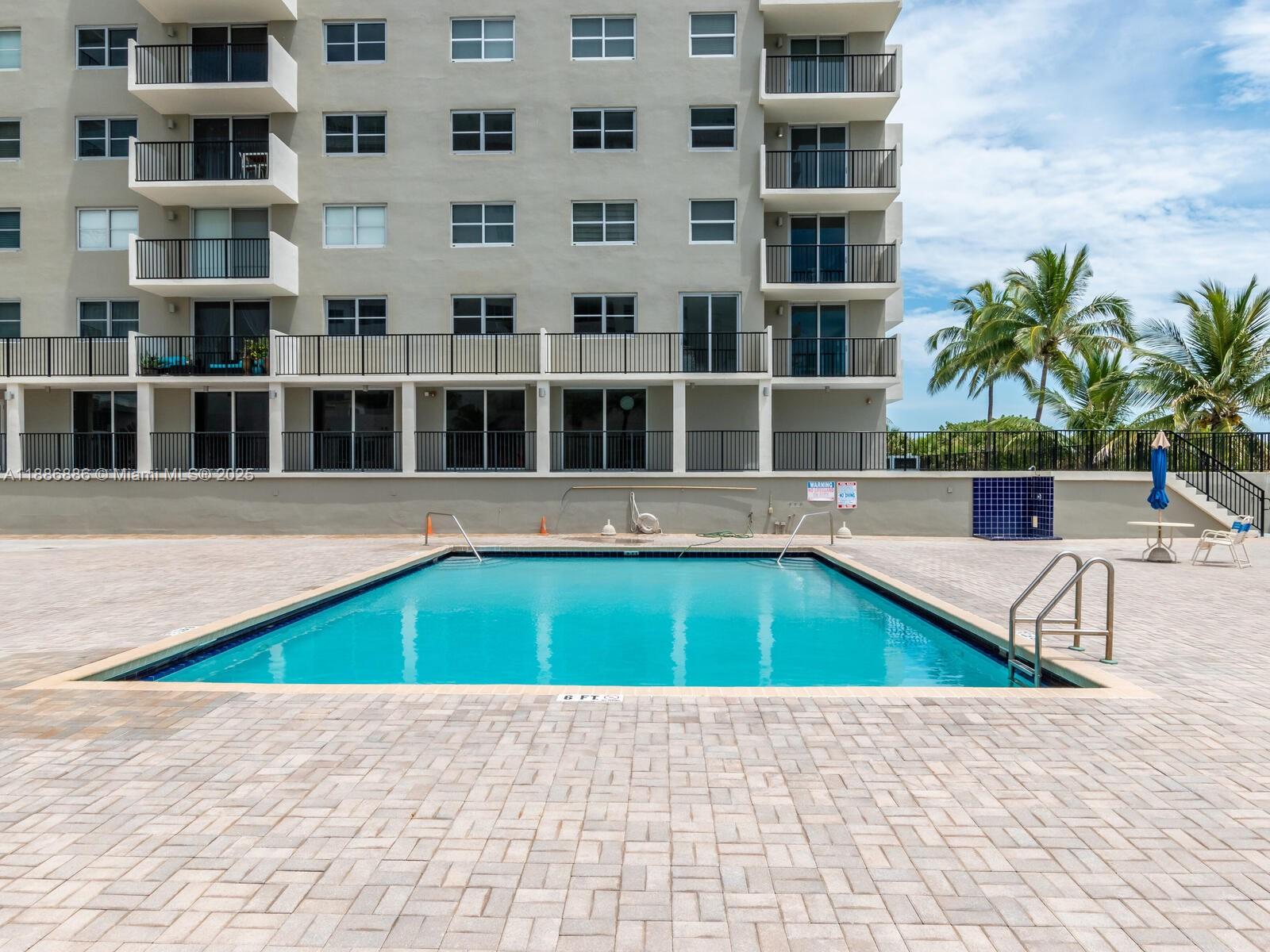 9273 Collins Avenue, Unit 703 Surfside, FL 33154 - Photo 32 of 49 a small pool with tall buildings in the background