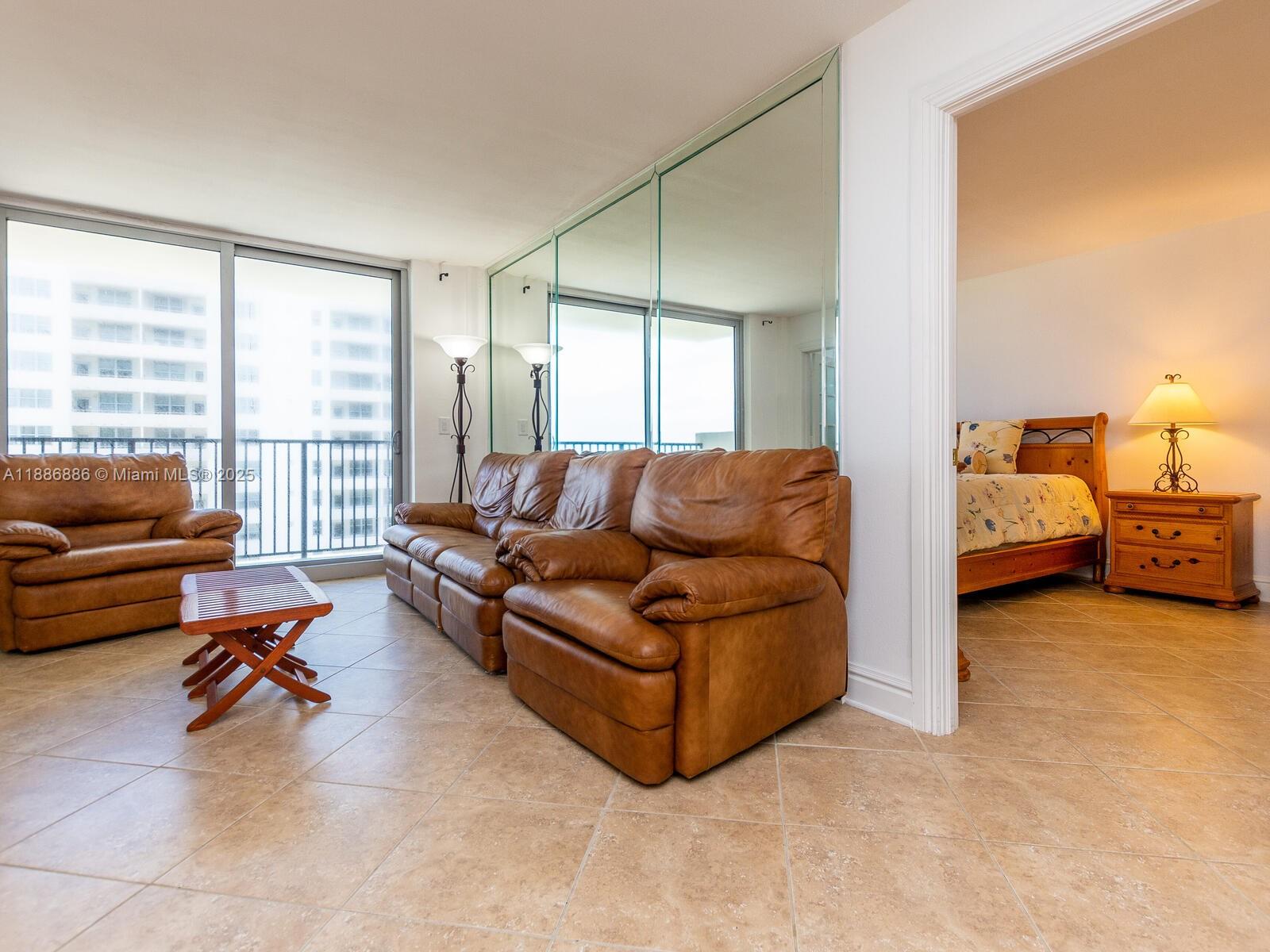 9273 Collins Avenue, Unit 703 Surfside, FL 33154 - Photo 4 of 49 a living room with furniture and a large window with outer view