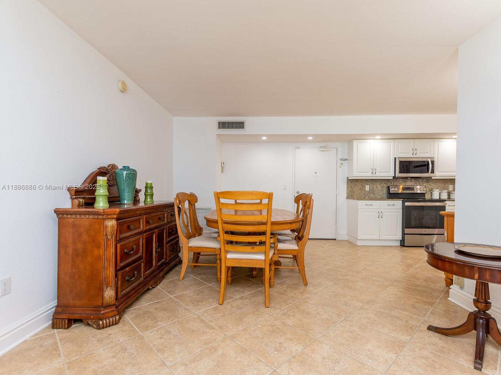 9273 Collins Avenue, Unit 703 Surfside, FL 33154 - Photo 5 of 49 a dining room with furniture and kitchen view