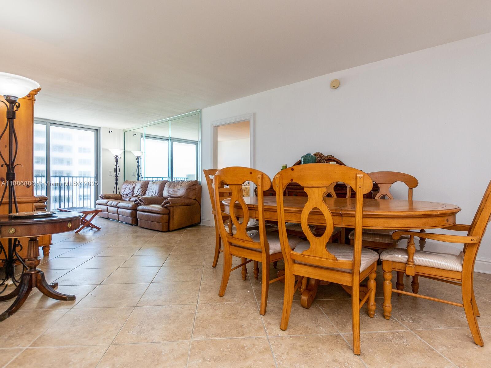 9273 Collins Avenue, Unit 703 Surfside, FL 33154 - Photo 6 of 49 a living room with furniture a table and a large window