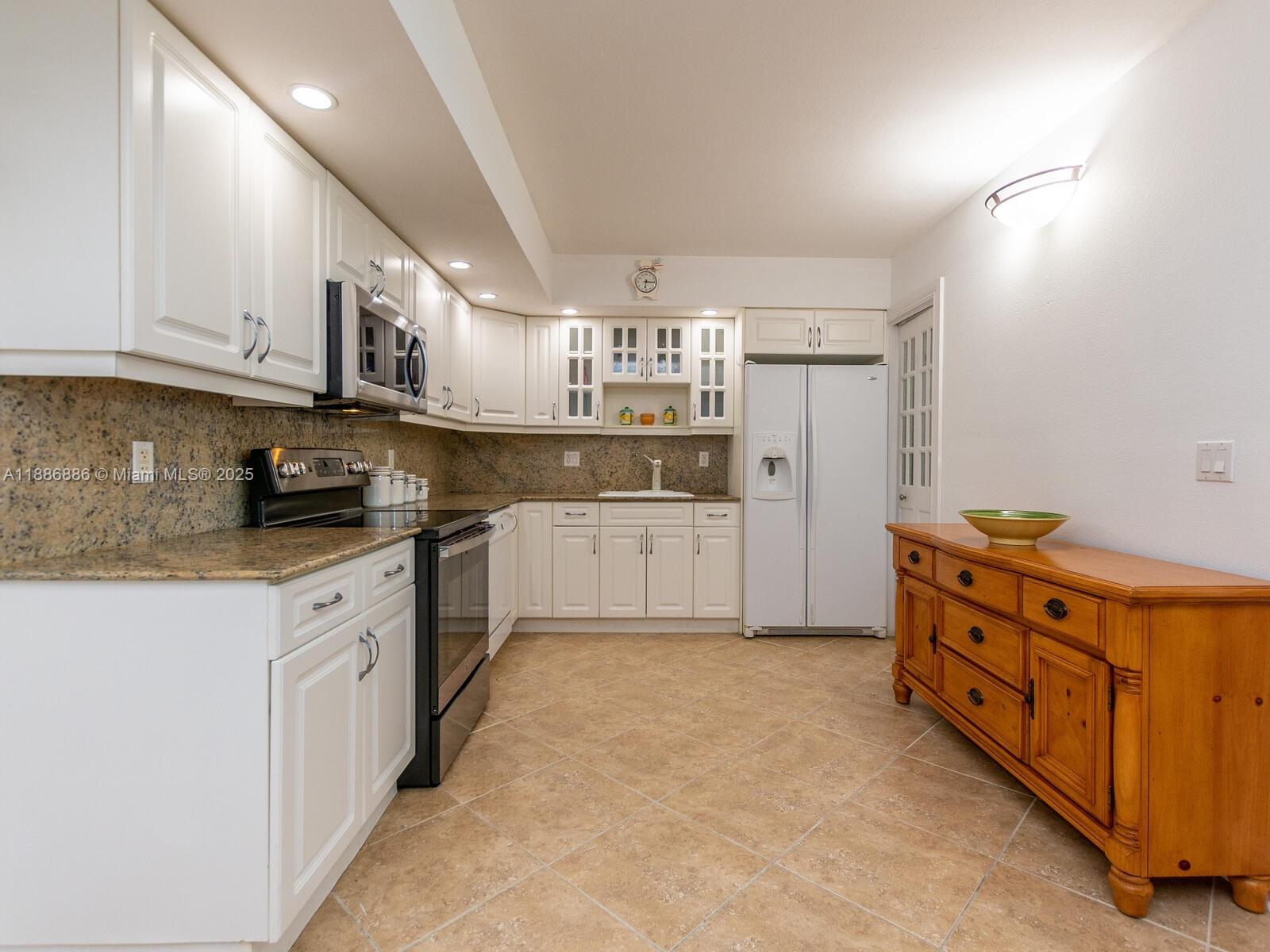 9273 Collins Avenue, Unit 703 Surfside, FL 33154 - Photo 7 of 49 a kitchen with stainless steel appliances granite countertop a refrigerator and a stove top oven