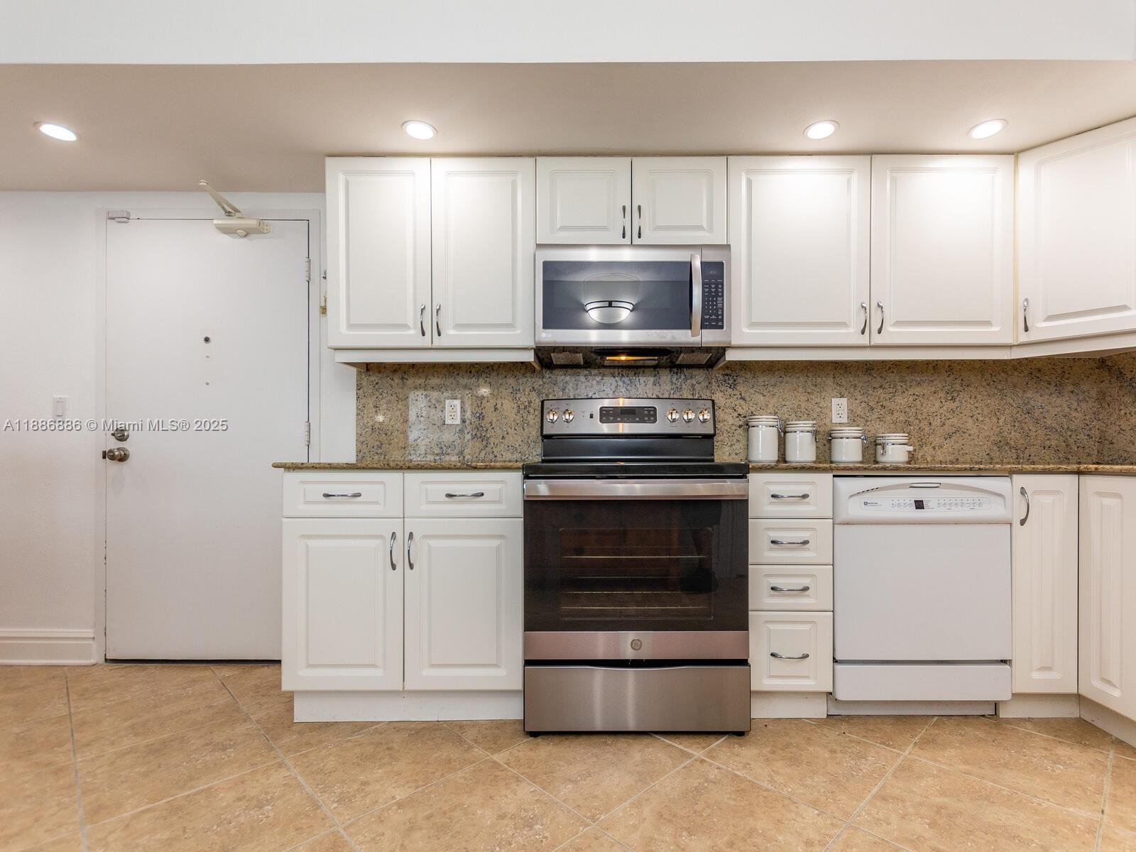 9273 Collins Avenue, Unit 703 Surfside, FL 33154 - Photo 9 of 49 a kitchen with stainless steel appliances granite countertop a stove a sink and a refrigerator