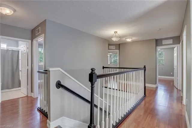 a view of a hallway with entryway and wooden floor