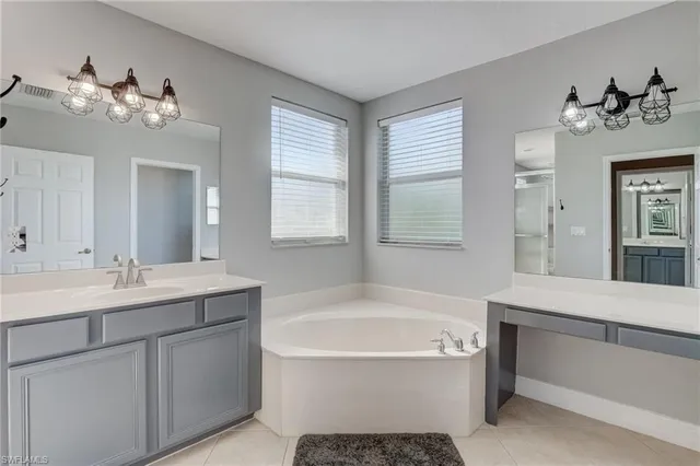 a bathroom with a tub sink and mirror