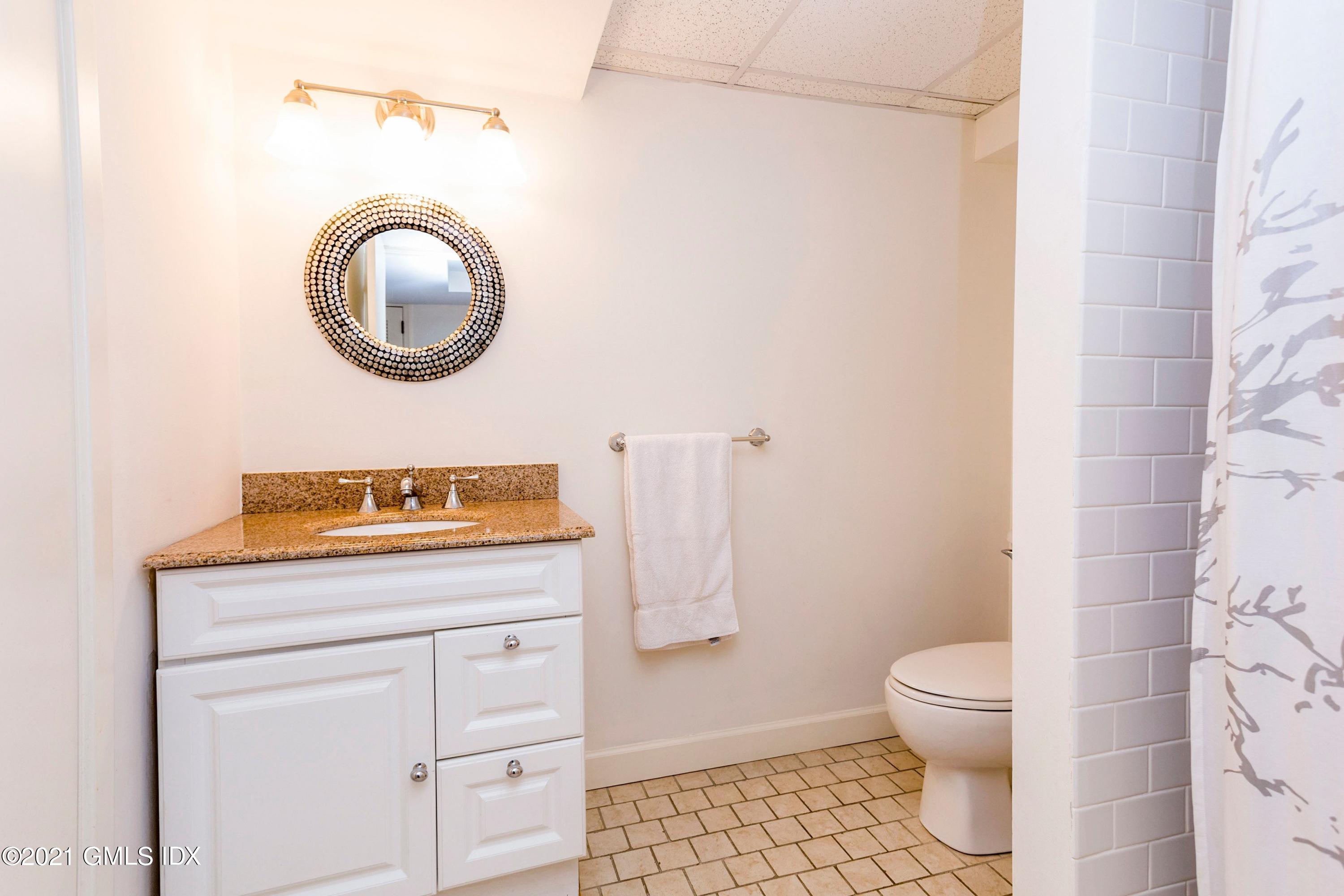 23 Stanwich Road Greenwich, CT 06830 - Photo 22 of 25 a bathroom with a granite countertop toilet sink and mirror