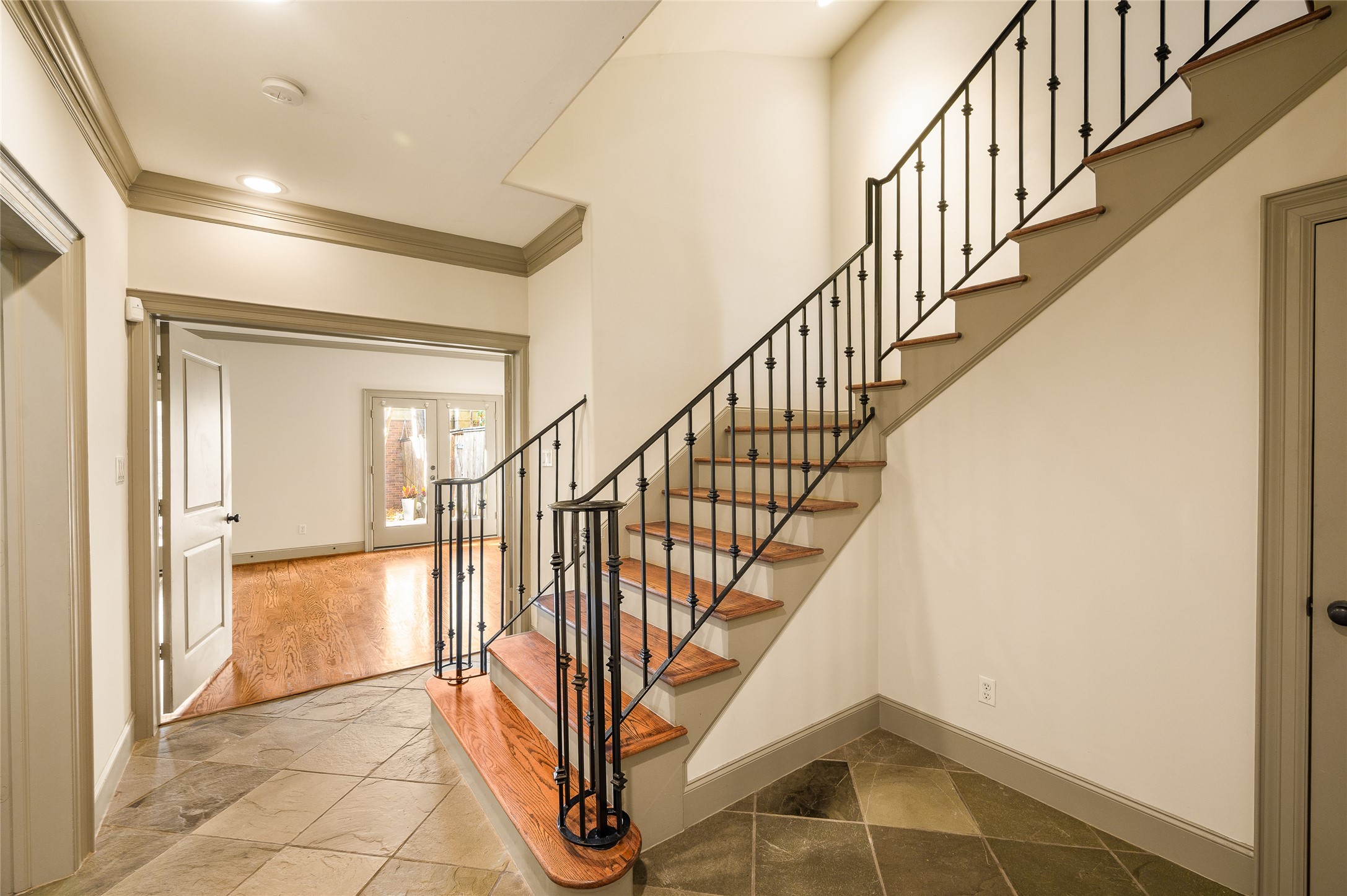 1655 Castle Court Houston, TX 77006 - Photo 10 of 32 Your drop zone/garage entryway with stairs leading to the living area. A secondary bedroom is beyond the French doors.