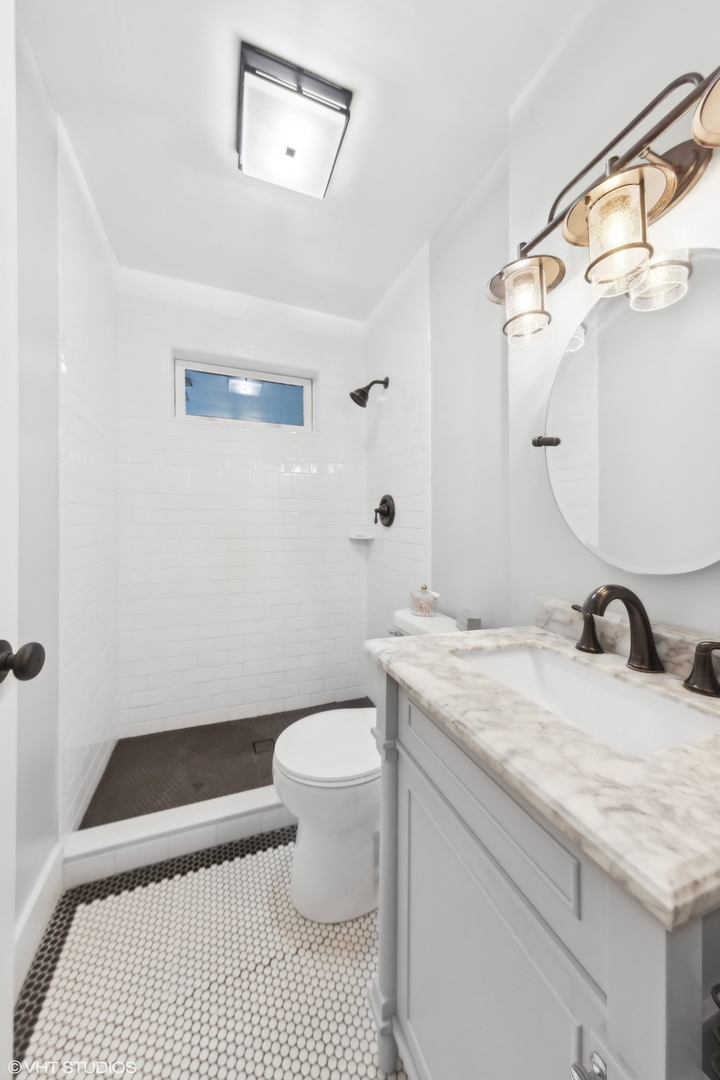 410 Mills Street Hinsdale, IL 60521 - Photo 14 of 22 a bathroom with a granite countertop sink a toilet and a mirror