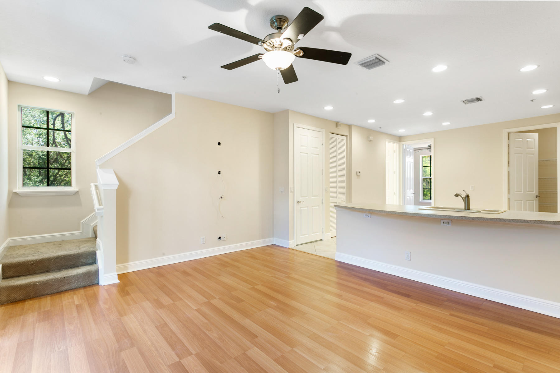 802 University Boulevard Jupiter, FL 33458 - Photo 3 of 16 a view of an empty room with wooden floor and a ceiling fan
