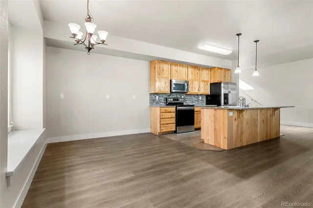 a kitchen with stainless steel appliances granite countertop a sink a stove top oven a counter space and cabinets