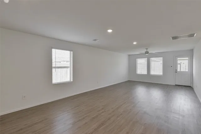 an empty room with a window and a ceiling fan
