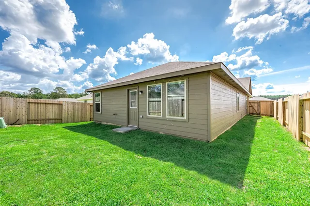 a view of a backyard with plants and large trees